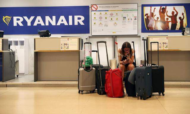 A stranded Ryanair passenger checks her phone at the Adolfo Suarez Madrid Barajas airport in Madrid