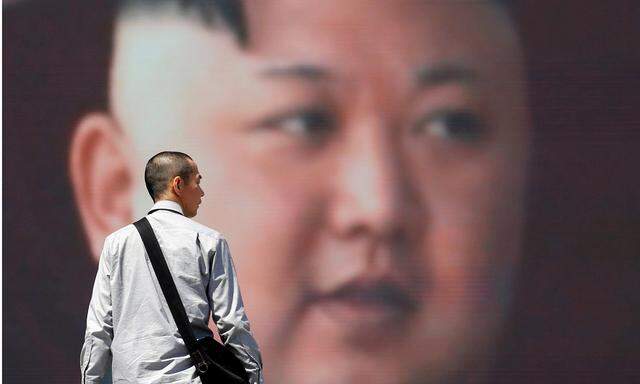 A man walks past a street monitor showing North Korea´s leader Kim Jong Un in a news report about North Korea´s announcement, in Tokyo