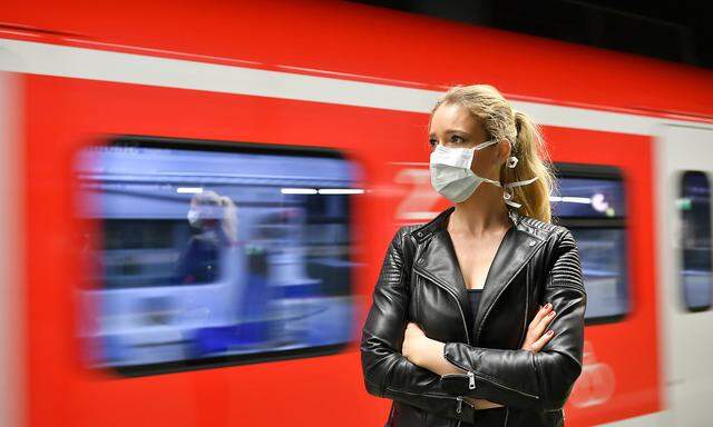 Frau mit Mundschutzmaske, wartet auf Zug, S-Bahn, Corona-Krise, Stuttgart, Baden-Wuerttemberg, Deutschland Coronavirus *