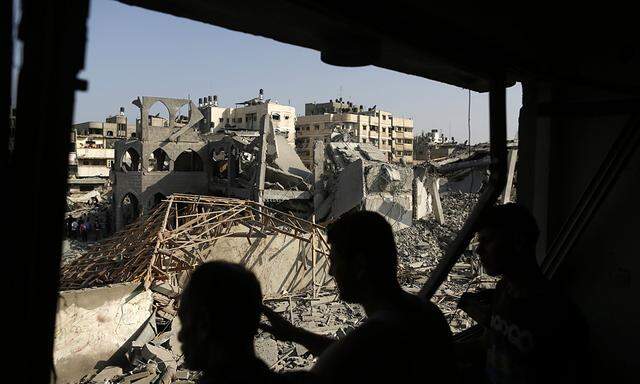 Palestinians look at the remains of a mosque, which witnesses said was hit in an Israeli air strike, in Gaza City