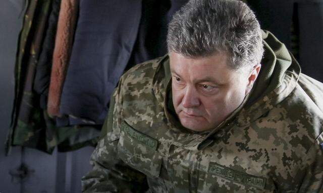 Ukraine's President Poroshenko talks to Chief of Staff of Ukraine's Armed Forces Viktor Muzhenko aboard a helicopter as they travel to Artemivsk to meet servicemen