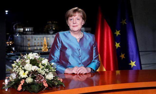 German Chancellor Angela Merkel poses for photographs after the television recording of her annual New Year's speech at the Chancellery in Berlin