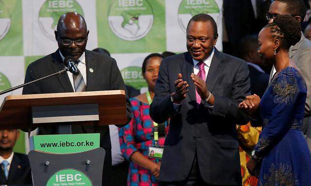 Incumbent President Uhuru Kenyatta applauds after he was announced winner of the presidential election at the IEBC National Tallying centre at the Bomas of Kenya