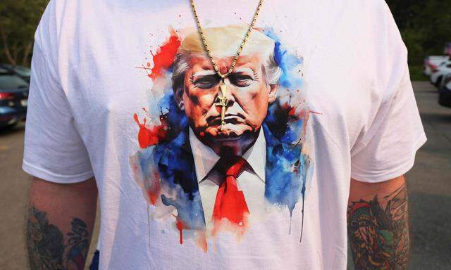 Ein Unterstützer von Ex-Präsident Trump trägt ein Fan-Shirt und eine Goldkette mit Schnellfeuerwaffen-Anhänger zu einer republikanischen Veranstaltung im Juni in New Hampshire. (Archivbild)