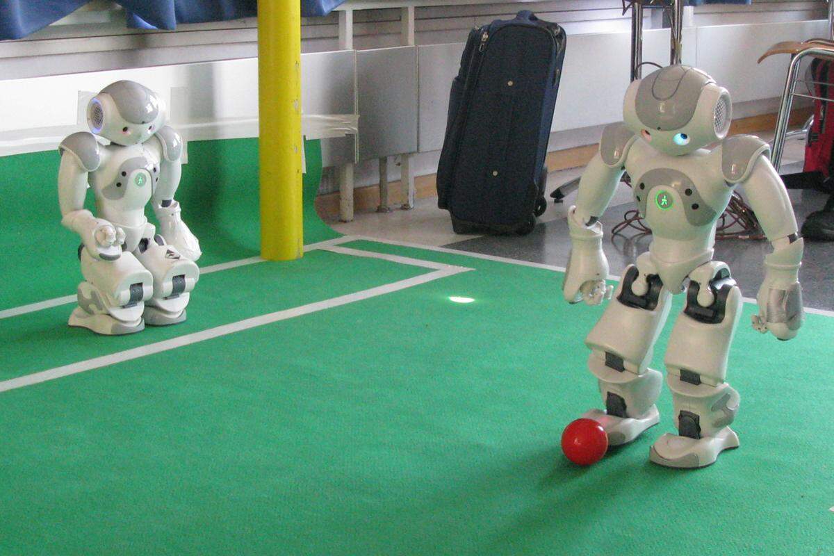 Grundsätzlich funktioniert Roboter-Fußball so, dass die künstlichen Kicker ihre Umgebung nach einem roten Ball und einem geben Rechteck absuchen. Das eine muss dann bekanntermaßen ins andere. Für Roboter ist das eine kognitive Höchstleistung.