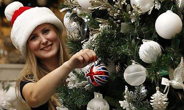 Selfridges employee Joanna Hetreed poses with a Union Jack Bauble, the best selling Christmas item, i