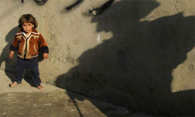 Symbolbild Krieg (Mädchen im Irak nebem dem Schatten eines US-Soldaten)