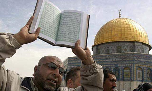ein Palästinenser hält in Jerusalem den Koran in die Höhe
