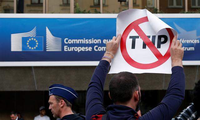 A demonstrator holds a sign during a protest against TTIP in Brussels