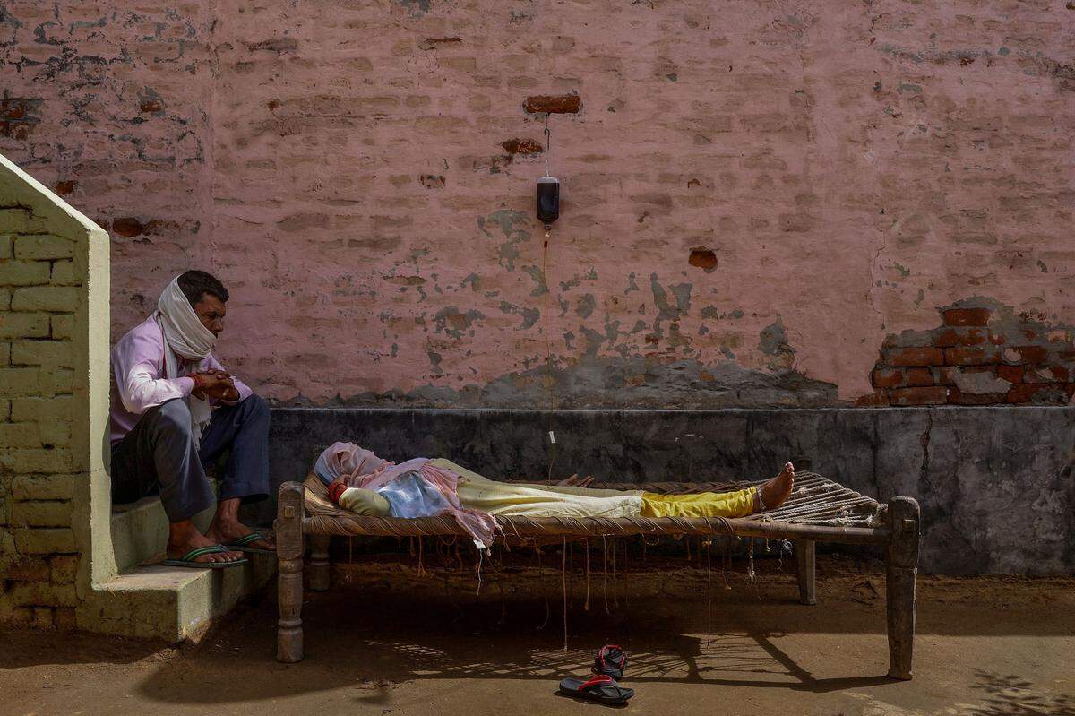 Eine mit Corona infizierte Frau in Uttar Pradesh, Indien, wird hydriert.