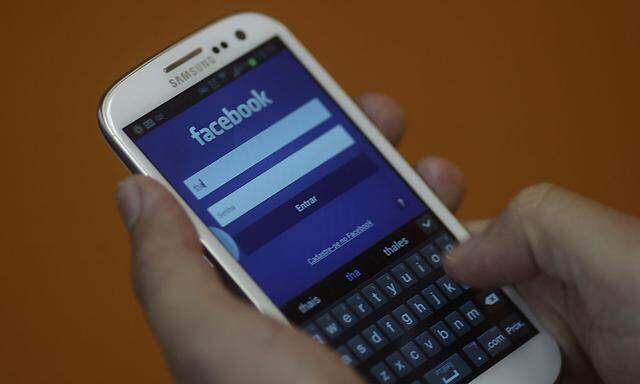 A smartphone user logs into his Facebook account in Rio de Janeiro