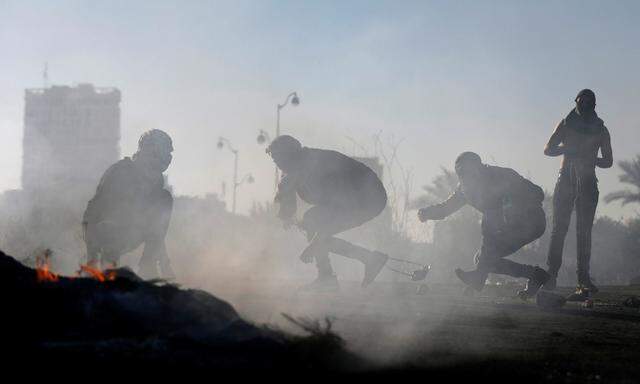 Palestinian protesters take cover during clashes with Israeli troops near the Jewish settlement of Beit El, near the West Bank city of Ramalla