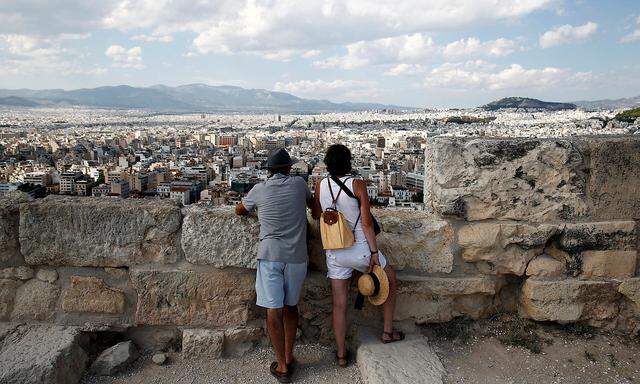 Tourists enjoy the view from the Acropolis hill in Athens