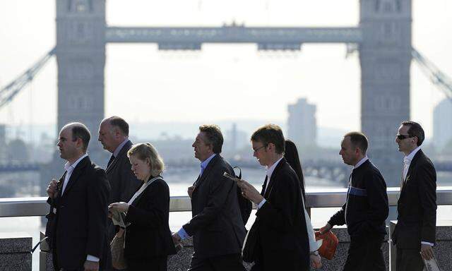 City workers cross London Bridge during the morning rush-hour in the City of London