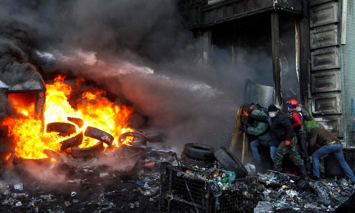 23. Jänner 2014. Pro-europäische Demonstranten suchen Schutz vor den Wasserwerfern der ukrainischen Polizei. Ab November 2013 demonstrierten auf dem Maidan in Kiew Hunderttausende Menschen. Anfang 2014 eskalierte die Gewalt. Im Februar 2014 starben mehr als 80 Menschen bei den Protesten.