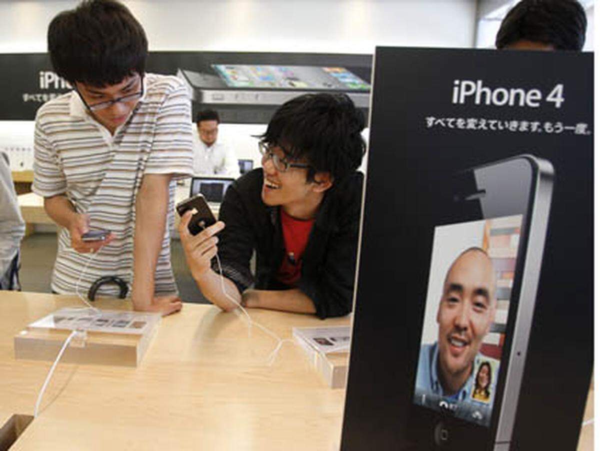 Zwei junge Männer begutachten das neue iPhone in Japan.