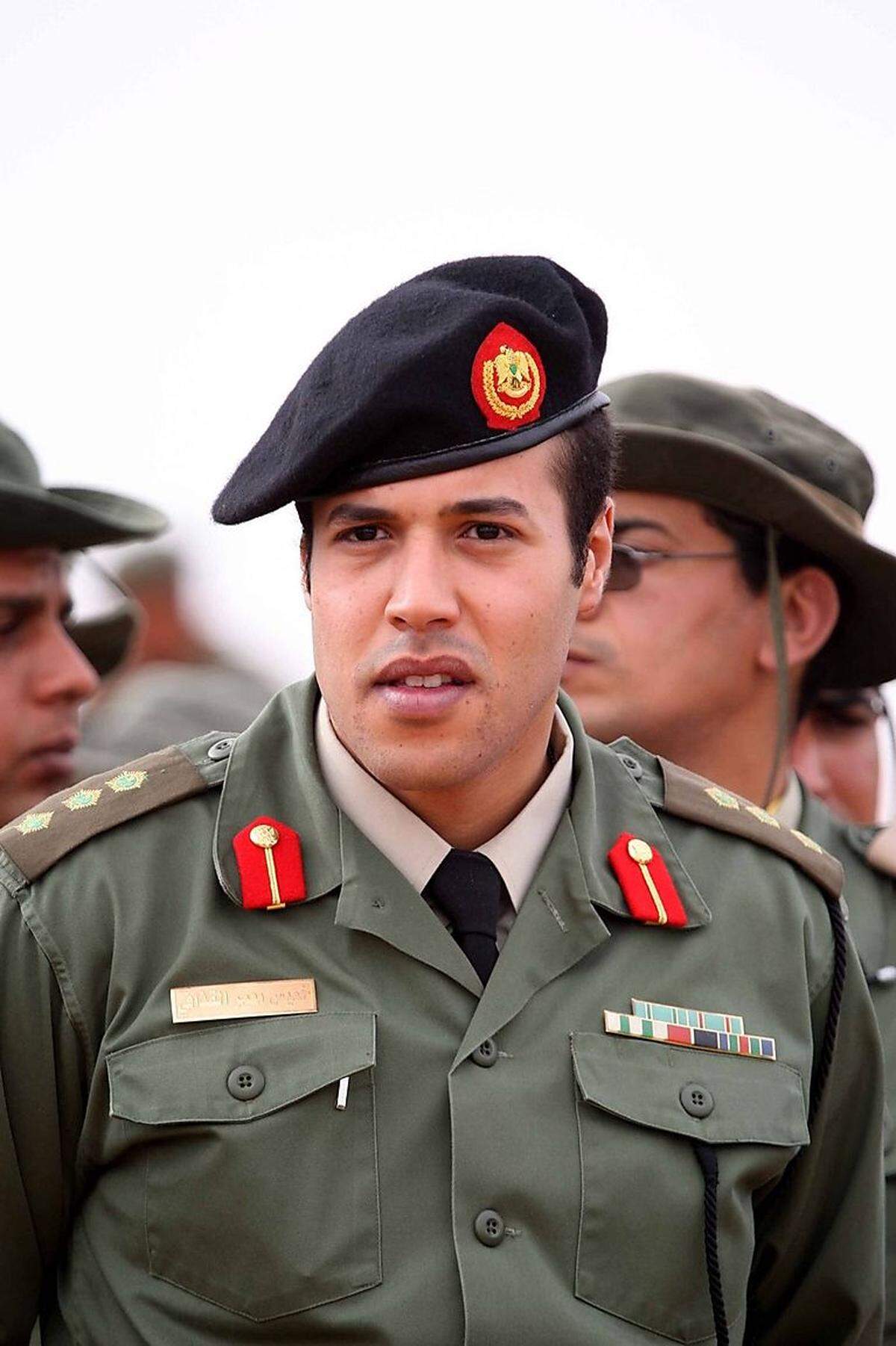 Der jüngste Sohn Gaddafis wurde 1983 geboren. Er kommandierte eine berüchtigte Eliteeinheit und galt als Hardliner. Der UN-Sicherheitsrat warf ihm vor, in die Repression von Demonstrationen verwickelt zu sein. Sein Tod wurde während der Revolte gegen Gaddafi mehrfach vermeldet und hat sich bisher nie bestätigt.
