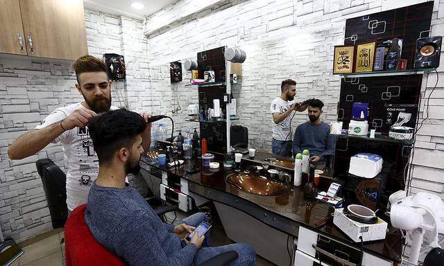 Serfo, a 23-year old Syrian Kurdish refugee from Aleppo, works in a barber shop in Istanbul