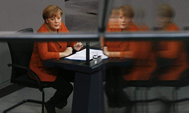 German Chancellor Merkel is reflected in glass fence at German  Bundestag in Berlin