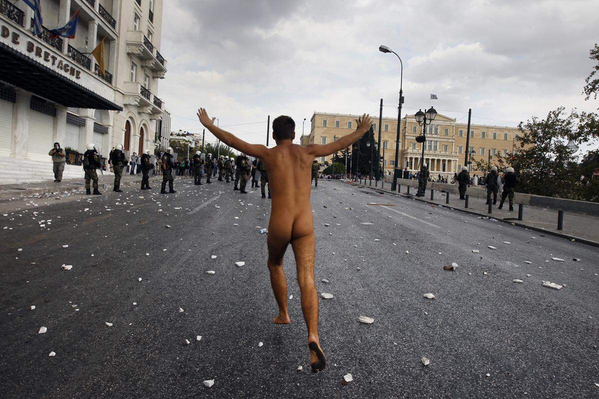 9. Oktober, Athen, Griechenland. Ein nackter Demonstrant macht seinem Ärger über den Besuch der deutschen Kanzlerin Luft.