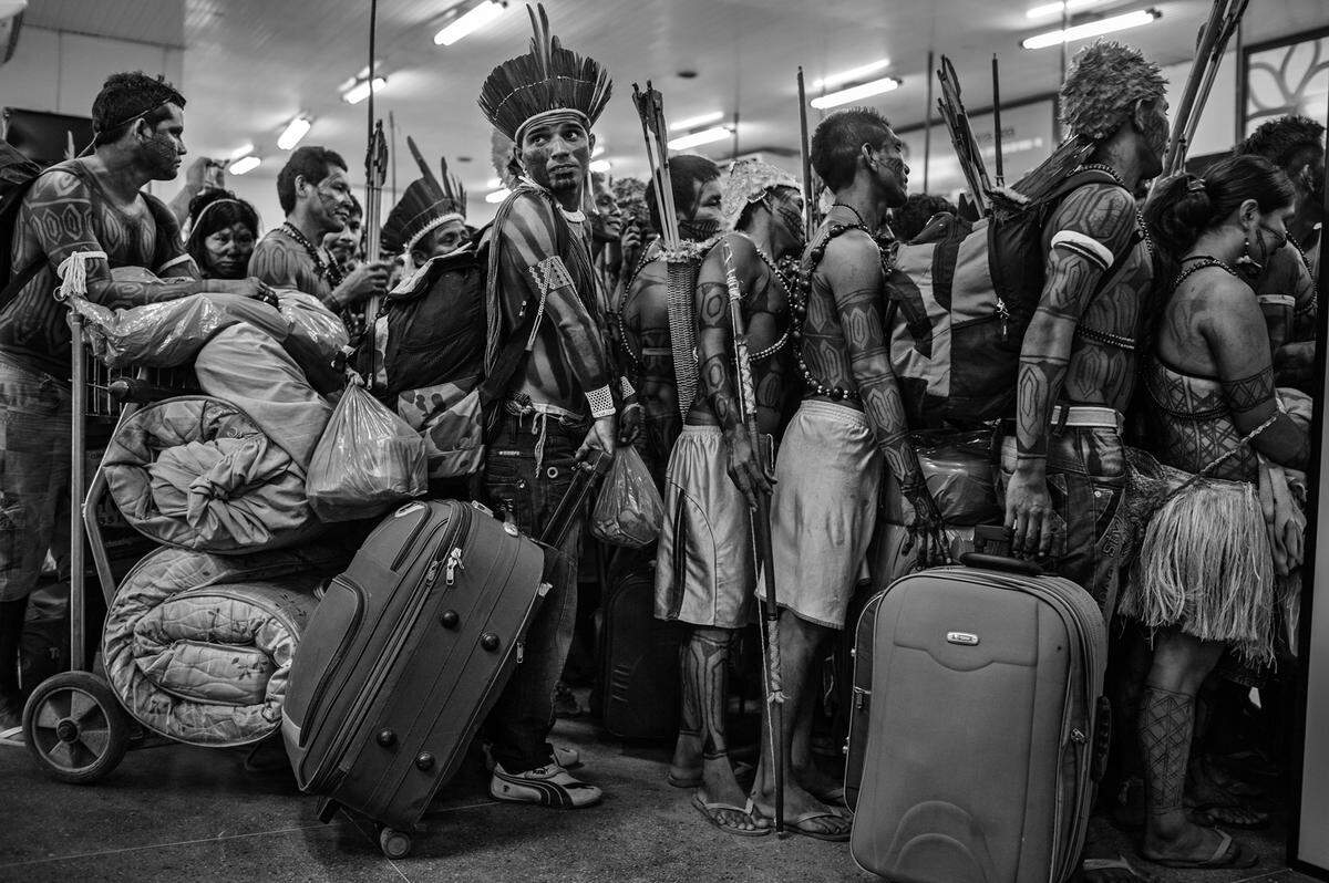 Mitglieder der Munduruku Gemeinschaft am Altamira Flughafen in Brasilien. Nachdem sie auf der Baustelle gegen den Belo-Monte-Damm protestiert haben, reisen sie in die Hauptstadt, um der Regierung ihr Anliegen vorzutragen. Das Bild machte ebenfalls Lalo de Almeida.