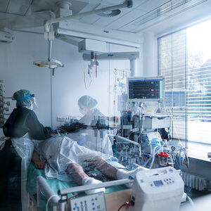 Mitarbeiterinnen der Pflege in Schutzausrüstung betreut einen Corona-Patienten am Universitätsklinikum Essen.