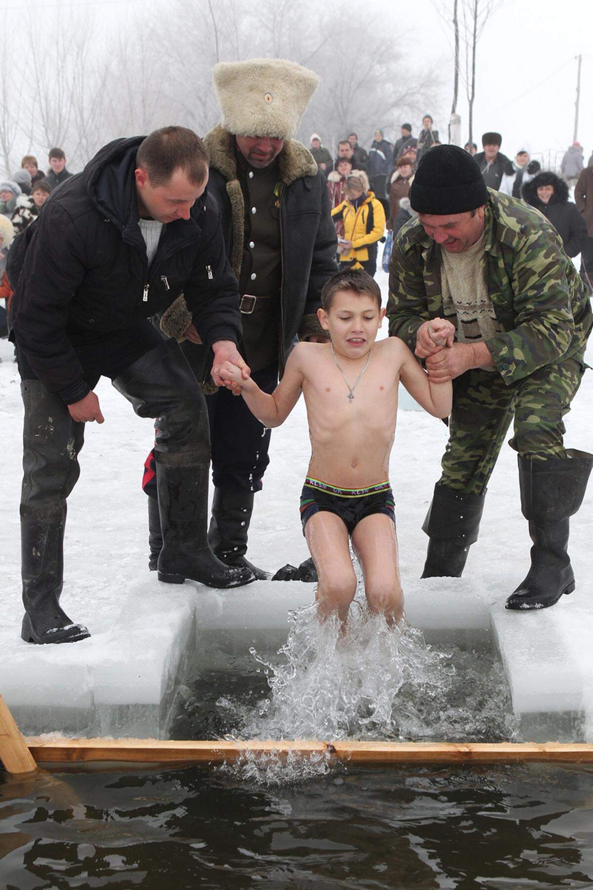 Hier in Bischkek, Kasachstan, werden die jüngeren von Helfern kurz ins Wasser getaucht.
