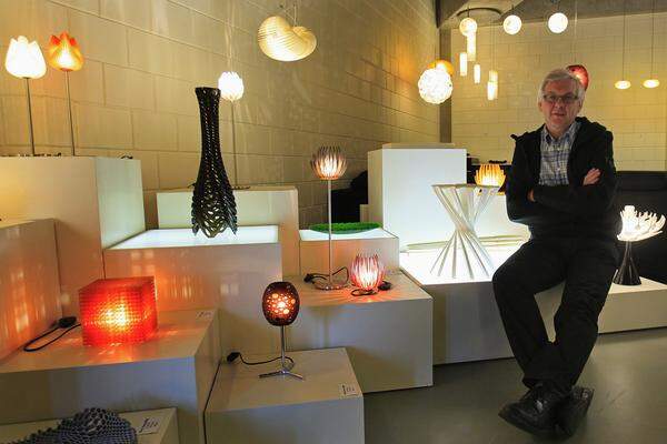 Materialise-Chef Wilfried Vancraen inmitten einer Sammlung ausgedruckter Lampen und Objekte.