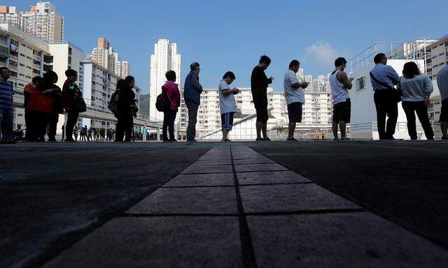 Lange Schlangen vor den Wahllokalen in der Finanzmetropole: Bei der Abstimmung in Hongkong zeichnete sich eine Rekordbeteiligung ab.