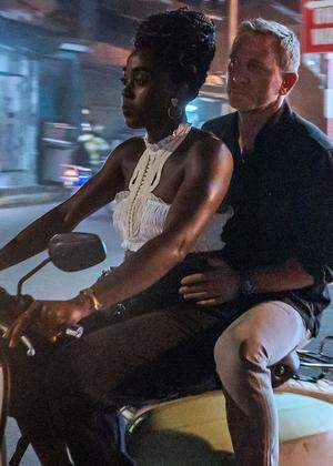 Kein alltäglicher Anblick: James Bond (Daniel Craig) als Beifahrer auf einem Moped im neuen Film „Keine Zeit zu sterben“. Am Steuer: Lashana Lynch.