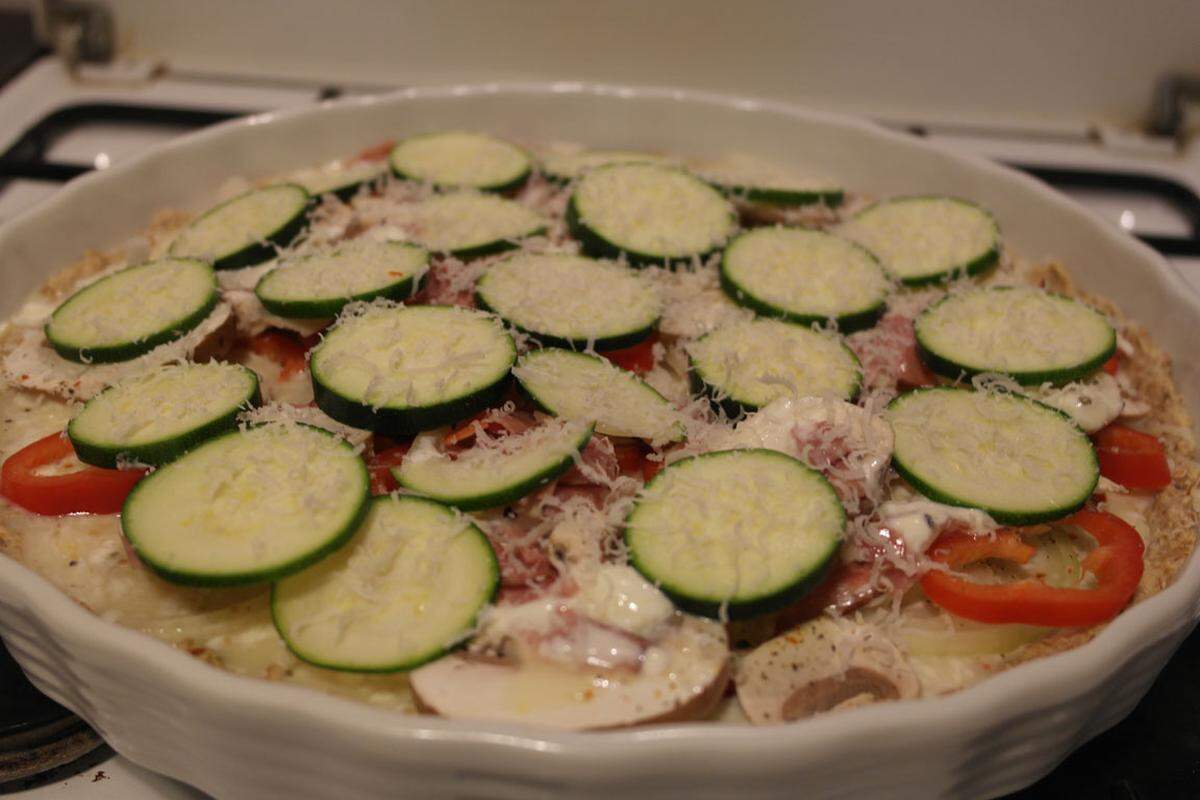 Zum Schluss die Zucchinischeiben anordnen und mit Parmesan bestreuen.