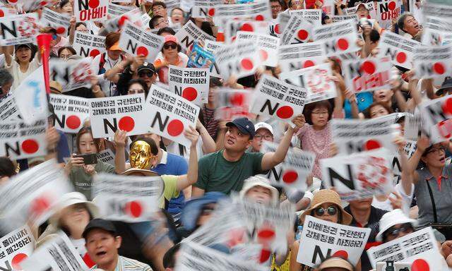 South Korean people chant slogans during an anti-Japan rally near the Japanese embassy in Seoul