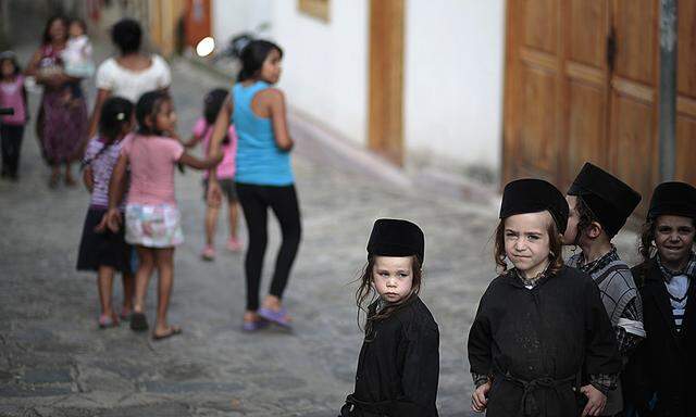 Children of a Jewish community stand on a street in the village of San Juan La Laguna