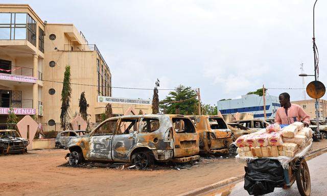 Ausgebrannte Wagen vor der Parteizentrale des abgesetzten Präsidenten Bazoum. Ein Ultimatum von Ecowas haben die Putschisten auch am Montag ignoriert. 