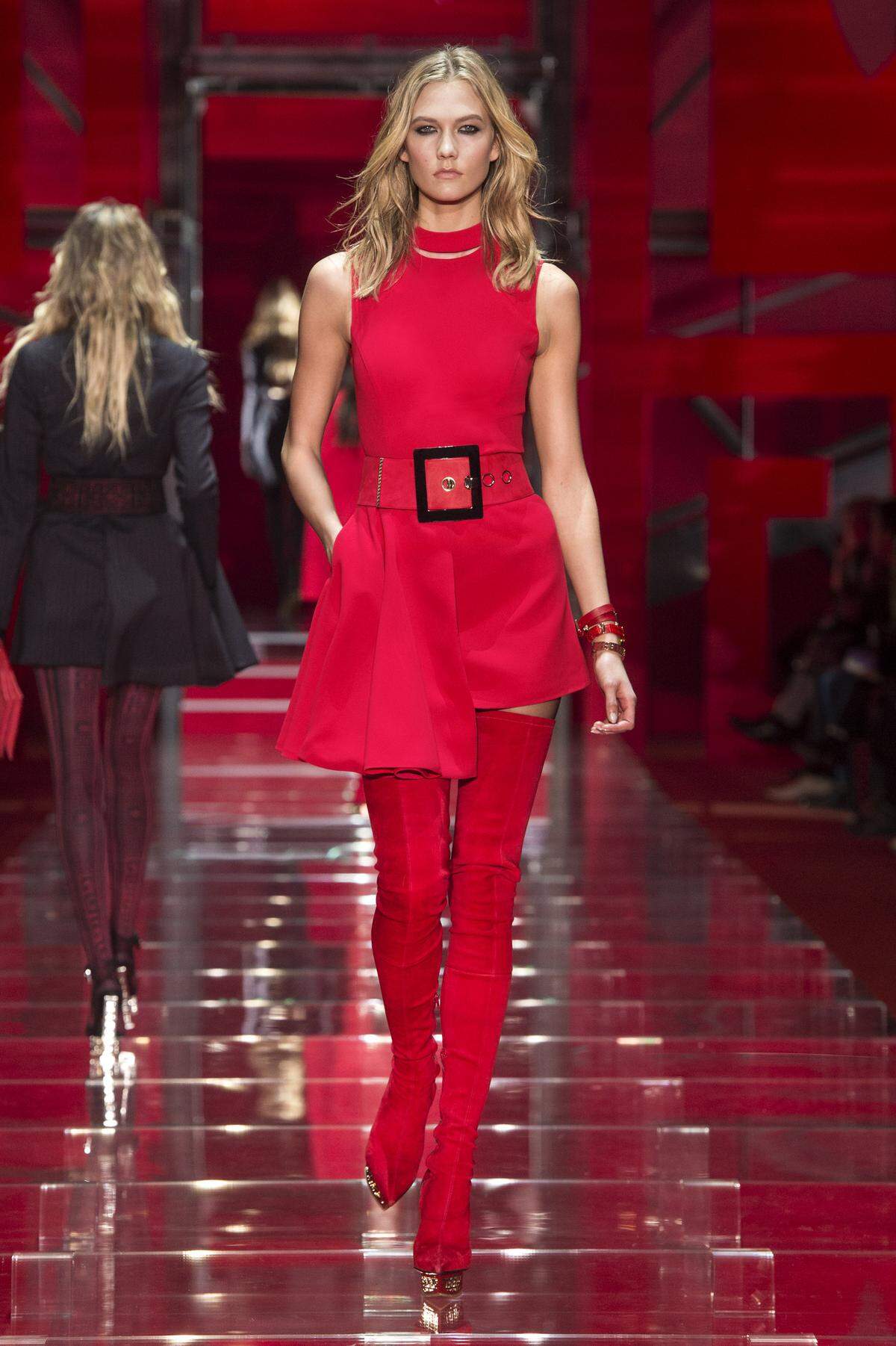 Overkneestiefel aus Veloursleder kombiniert mit einem assymetrischen Minikleid. Alles von Versace.