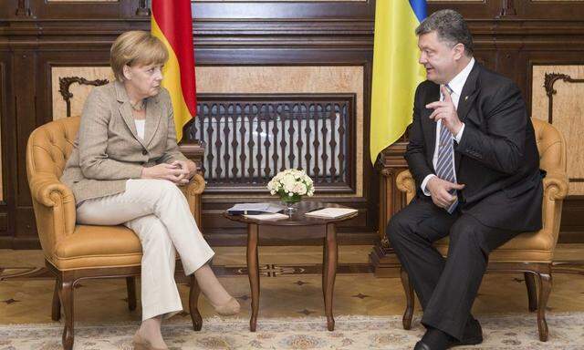 Germany´s Chancellor Merkel and Ukraine´s President Poroshenko speak during their meeting in Kiev