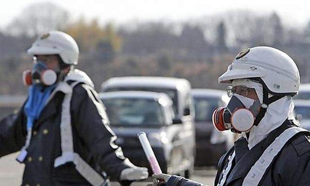 Police officers wearing respirators guide people to evacuate away from the Fukushima Daiichi 1 nuclea