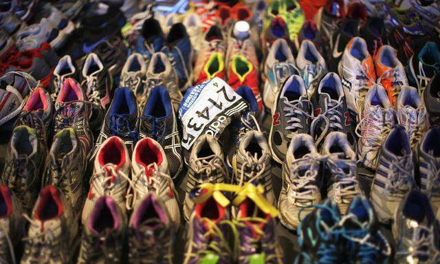 Participant number tag seen among running shoes left at makeshift memorial, in an exhibit at the Boston Public Library in Boston in this file photo