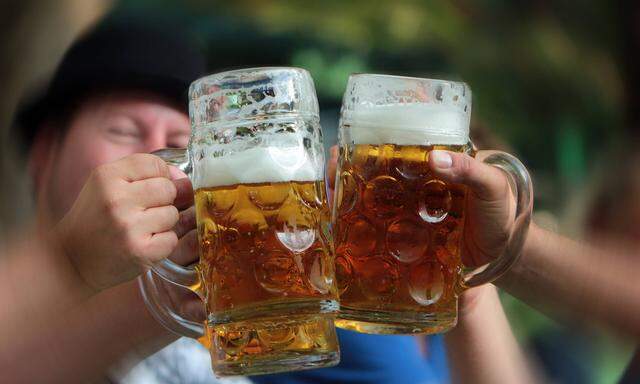 gemeinsames Zuprosten und Ansto�en mit einer Mass Bier im Biergarten in M�nchen Bayern Deutschland