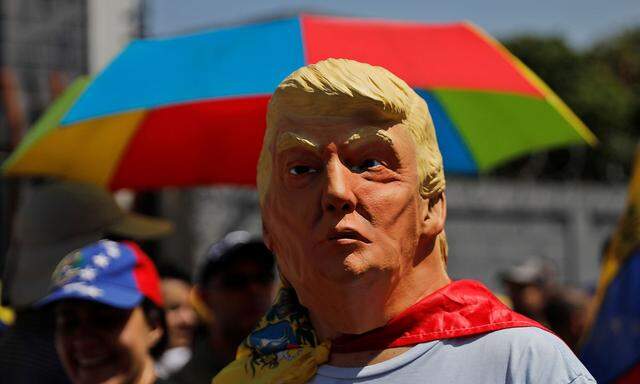 A man wearing a mask of U.S. President Donald Trump attends a rally against Venezuelan President Nicolas Maduro's government in Caracas
