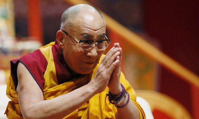 Tibet's exiled spiritual leader the Dalai Lama greets the audience before his second speech during the European Tibetan Buddhist Conference in Fribourg