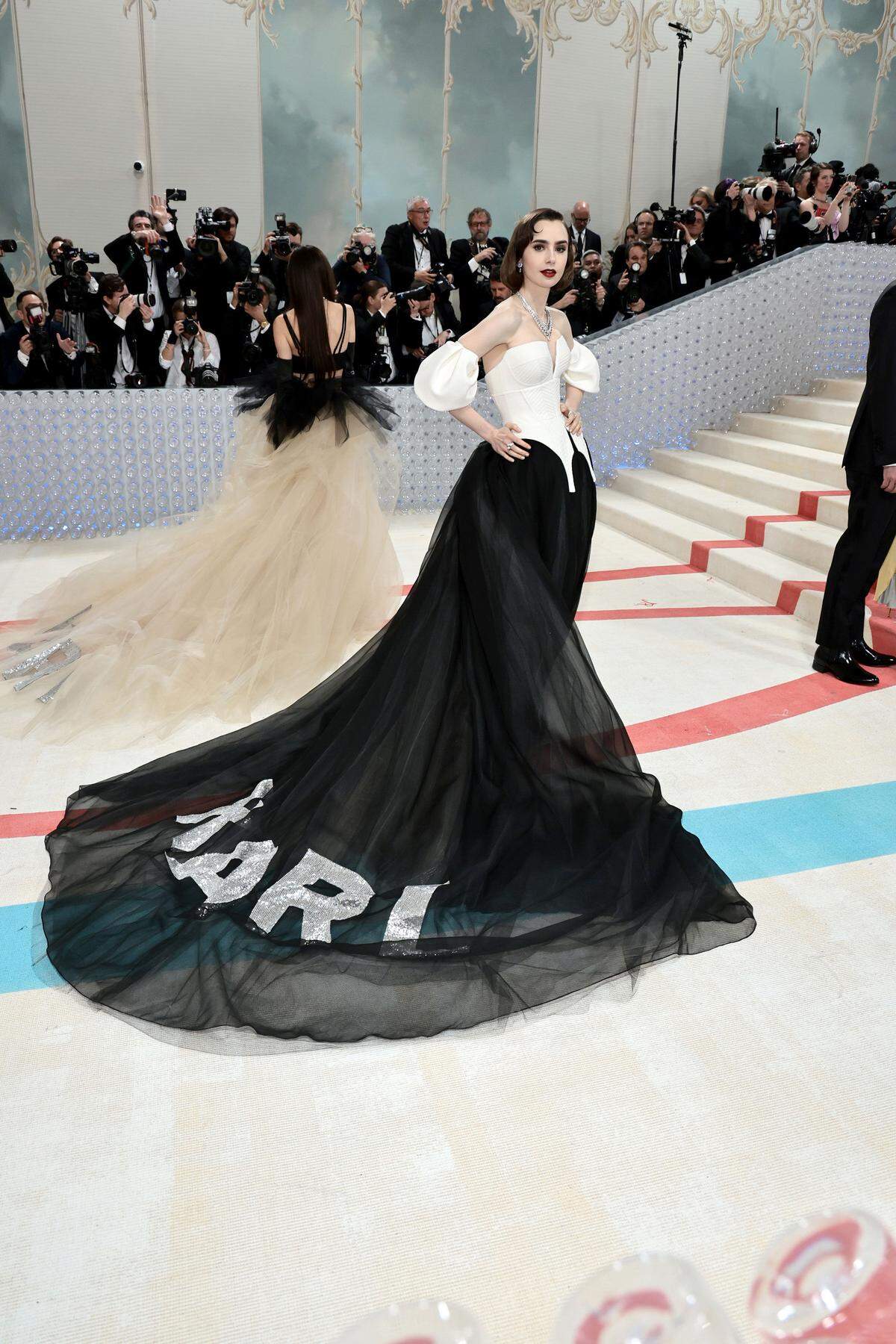 Auch eine Möglichkeit, dem Modezarr die letzte Ehre zu erweisen, wenn auch nicht die originellste: Lily Collins zog seinen Namen (zur Gänze aus Pailletten) hinter sich her. Das Kleid ist von Vera Wang. 