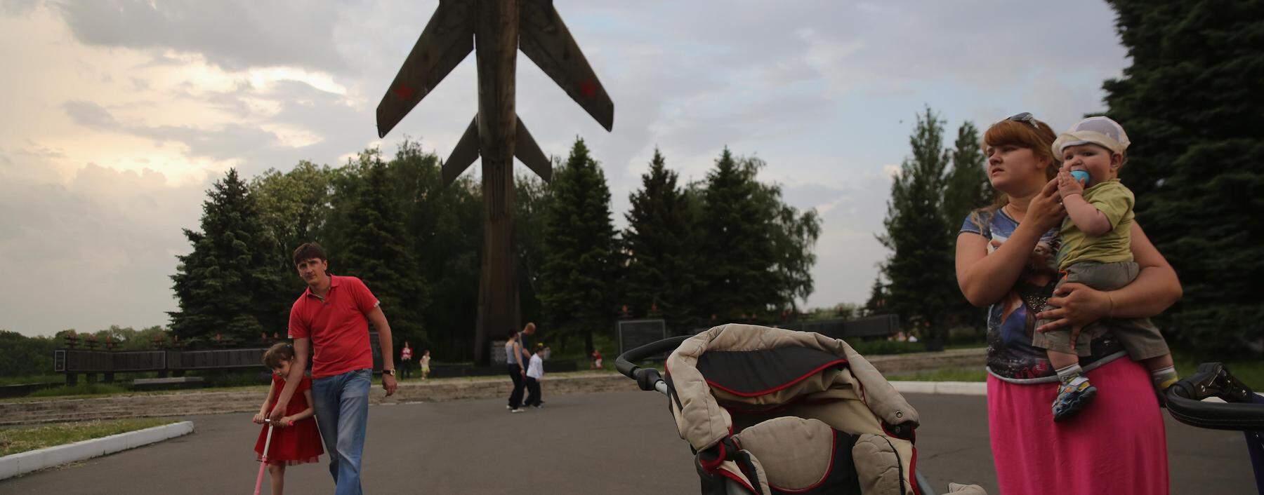 Szene aus dem Jahr 2014: eine Familie vor einem bekannten Weltkriegs-Denkmal in Awdijiwka.