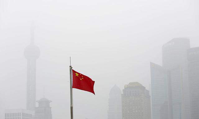 Chinese flag is seen in front of the financial district of Pudong amid heavy smog in Shanghai