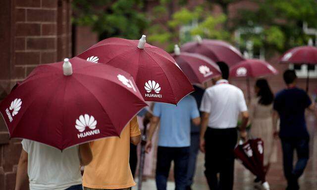 FILE PHOTO: Guests hold umbrellas with Huawei logos in the rain at Songshan Lake New Campus in Dongguan