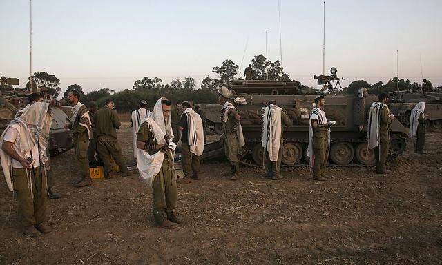 Israelische Soldaten in Gebetskleidung im Aufmarschgebiet am Rand des Gazastreifens.