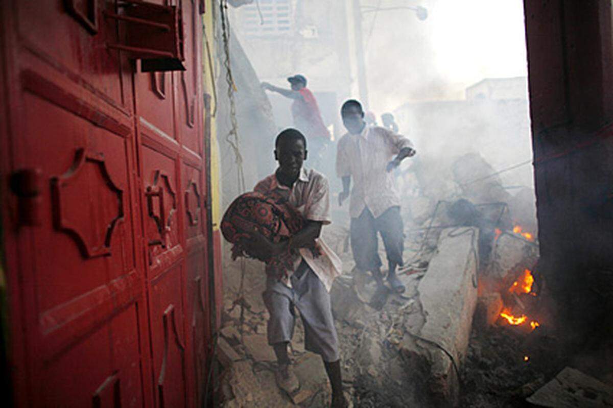 Das Erdbeben traf die Armen genauso wie die Bessergestellten. Vor der Katastrophe lebten 80 Prozent der Bevölkerung mit weniger als zwei Dollar (1,46 Euro) am Tag unter der Armutsgrenze. Im Bild: Plünderer treiben am 17. Jänner in Port-au-Prince ihr Unwesen.