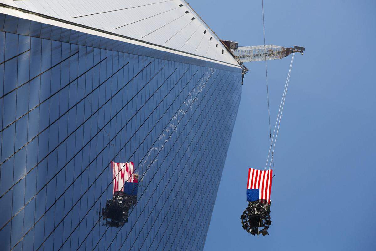 Spezialkräne hievten die beiden mit Flaggen bedeckten letzten Bauteile in gut 400 Meter Höhe.