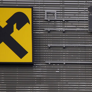Workers are suspended as they assemble letters of the Raiffeisen Polbank's bank logo on their new building in Warsaw