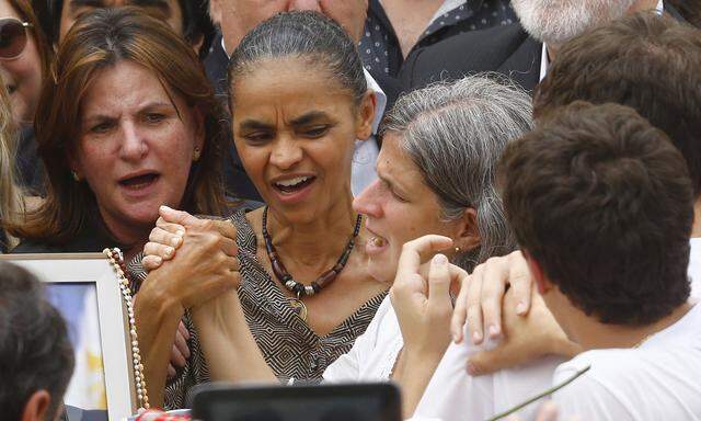 Brazilian politician Silva grabs the hand of the widow of Eduardo Campos in Recife